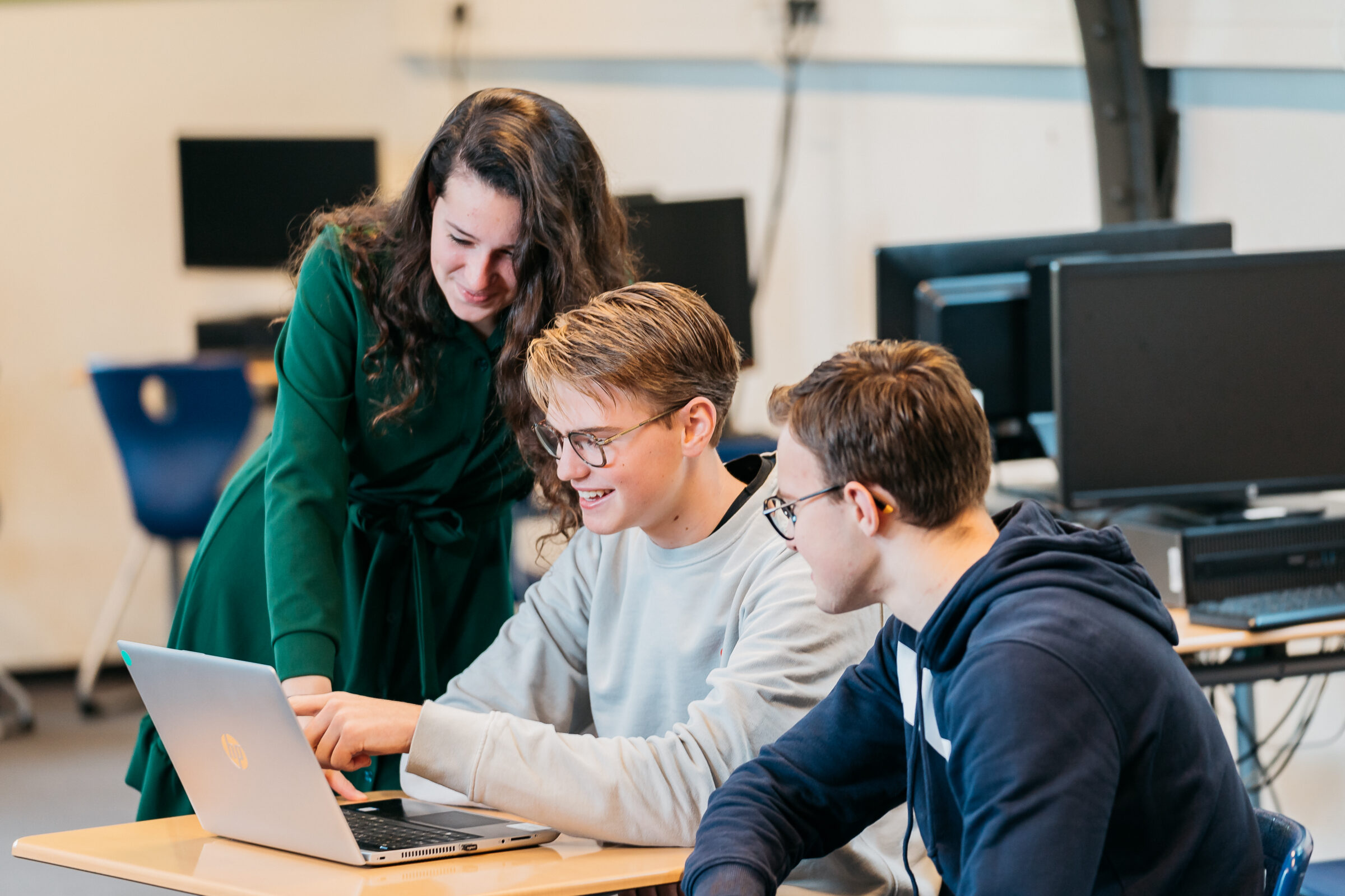 beeld van studenten rondom laptop