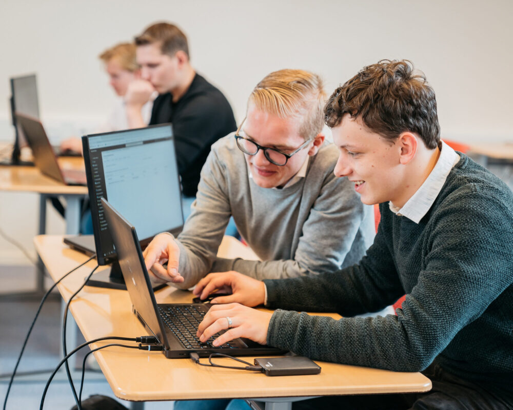 beeld studenten achter een laptop